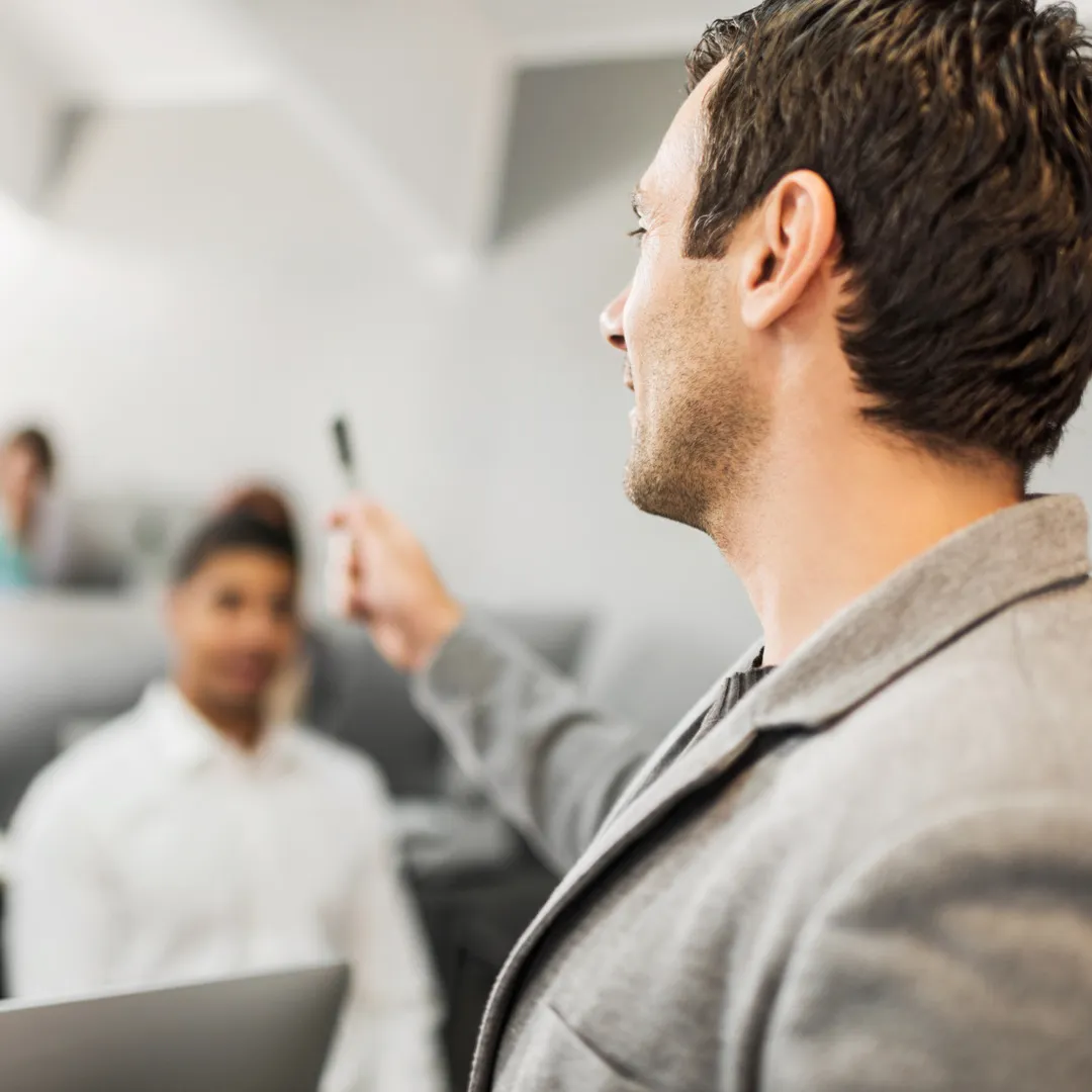 Flere mennesker i et møte der ett dekker nesten hele utsnittet.