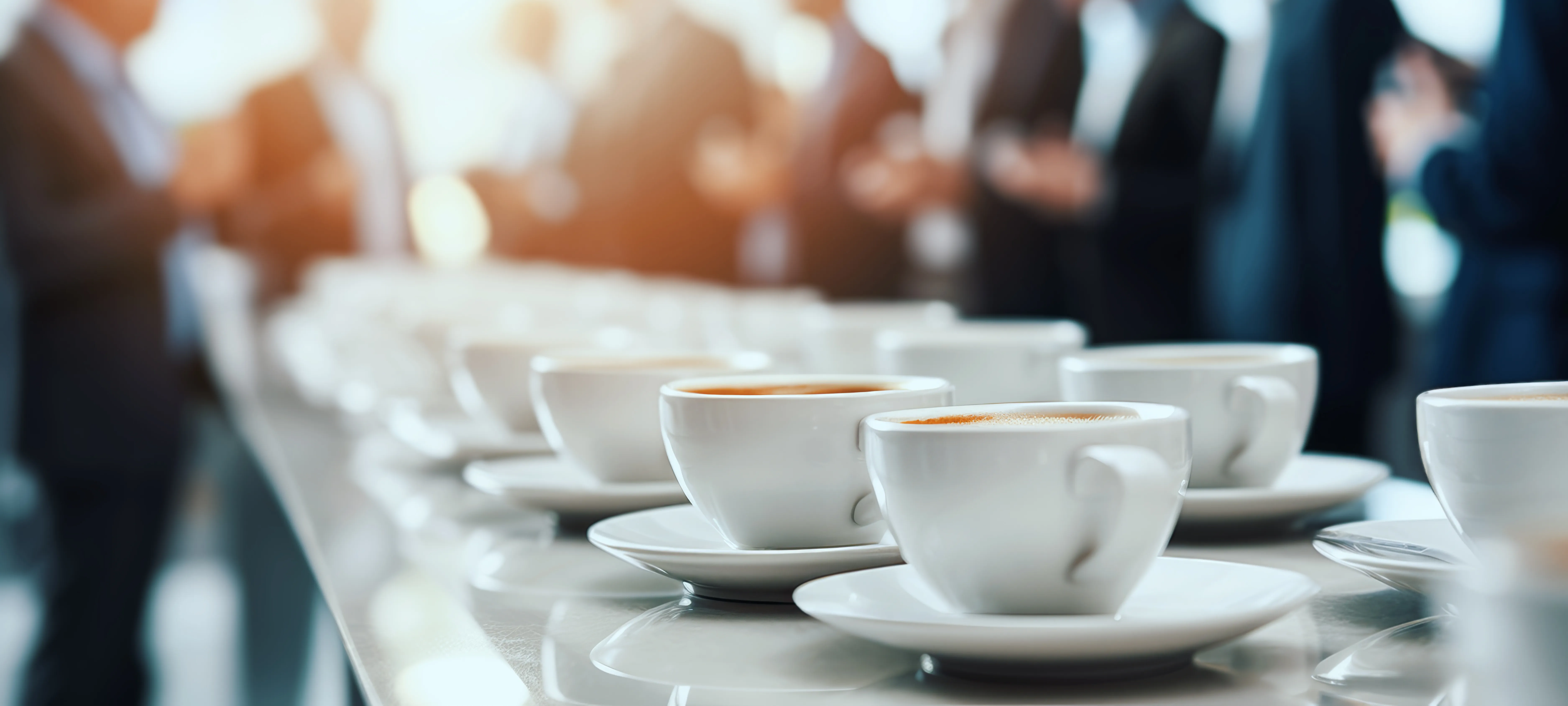 Et langt bord med kaffekopper